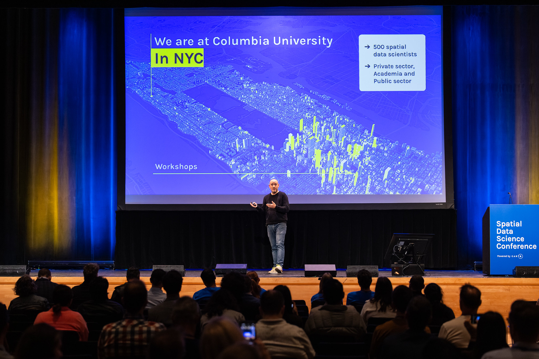 Speaker presenting on a Spatial Data Science Conference branded stage